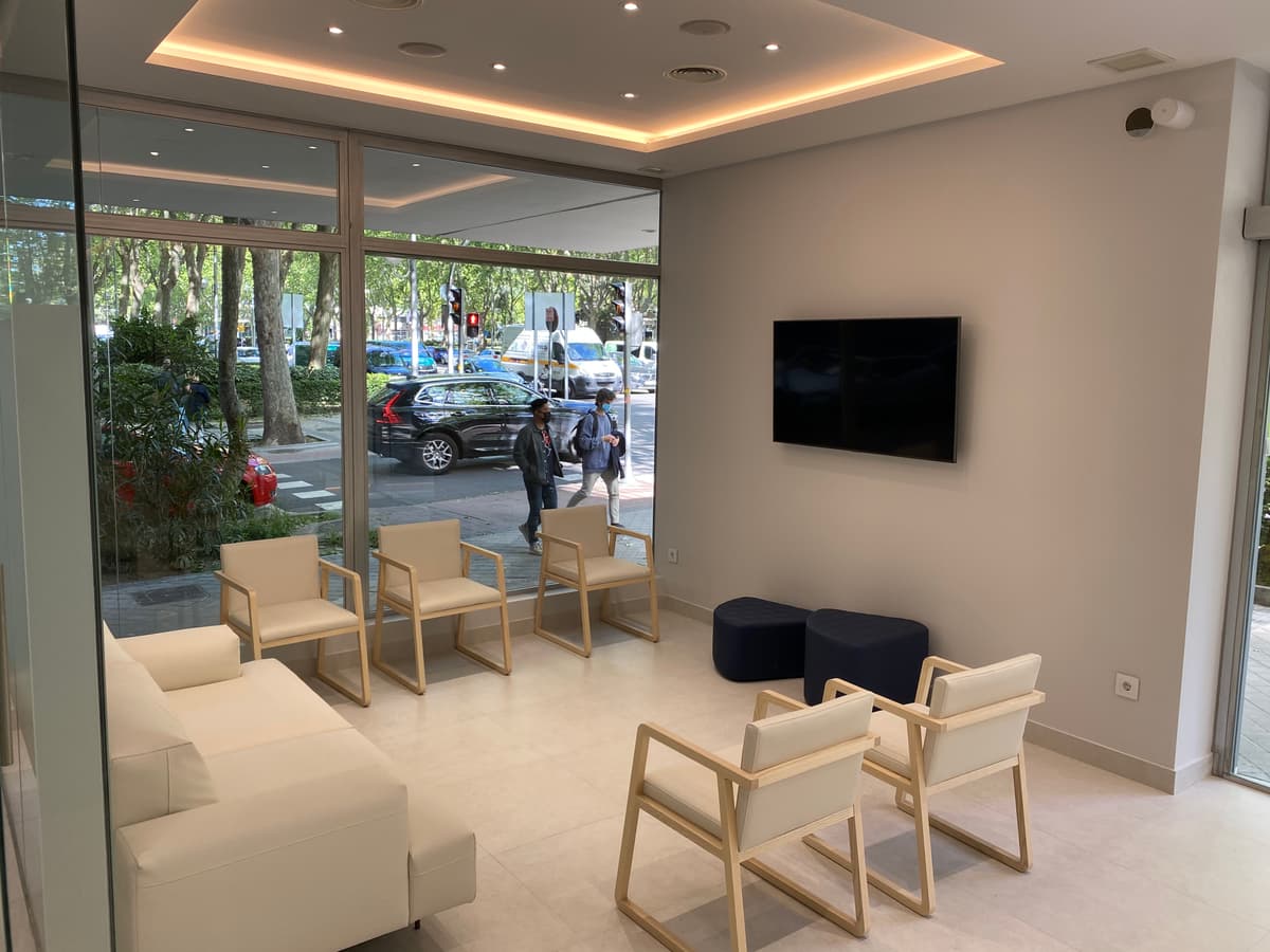 Área de recepción de clínica dental con un diseño abierto, moderno y funcional.